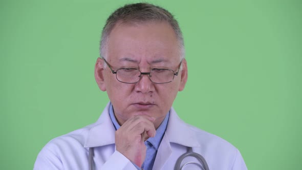 Face of Stressed Mature Japanese Man Doctor Thinking
