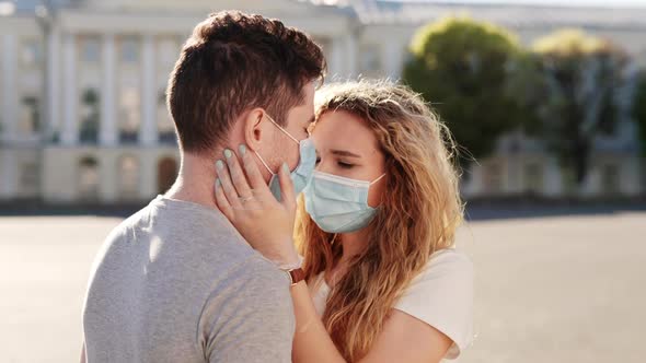 Young Family Couple in Love Medical Protective Masks in City Sunset