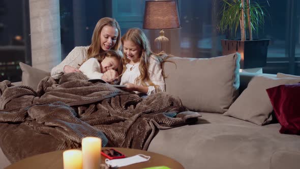 Mother Resting with Daughters on Couch and Painting in Album