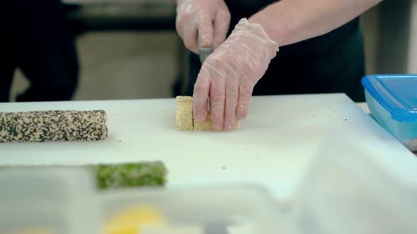 Cook Cuts a Japanese Roll with White Sesame