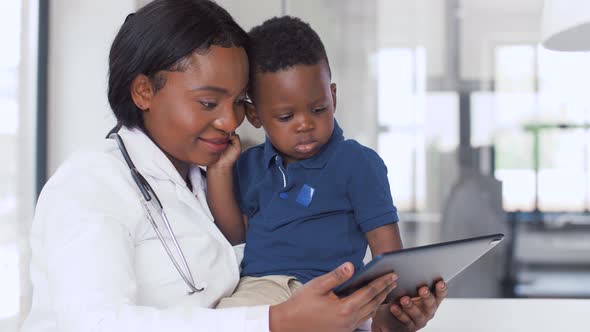 Doctor Showing Tablet Pc To Baby Patient at Clinic