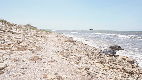 Closeup of a Rocky Seashore with Small Waves on a Sunny Summer Day