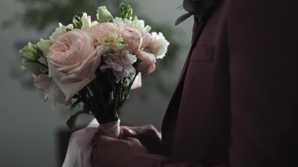 Groom in Elegant Tuxedo Holds Flowers Bouquet at Wedding