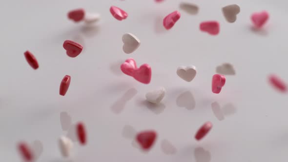 Valentine's Day heart shaped candy falling and bouncing in slow motion. Shot on Phantom Flex 4K. alt