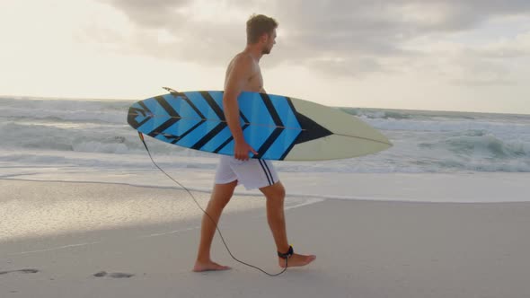 Man walking with surfboard at beach 4k