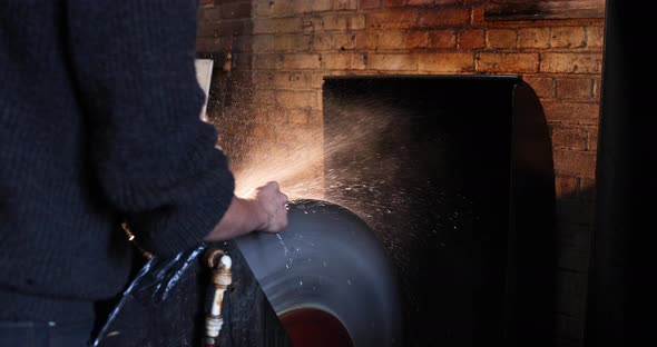 Bladesmith wet grinding a blade