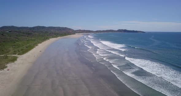 Aerial drone view of the beach, rocks and tide pools in Guiones, Nosara, Costa Rica