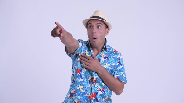 Young Happy Hispanic Tourist Man Pointing Finger and Looking Surprised