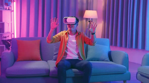 Young Asian Man Wearing Vr Headset At Living Room, Cyan And Magenta Colors