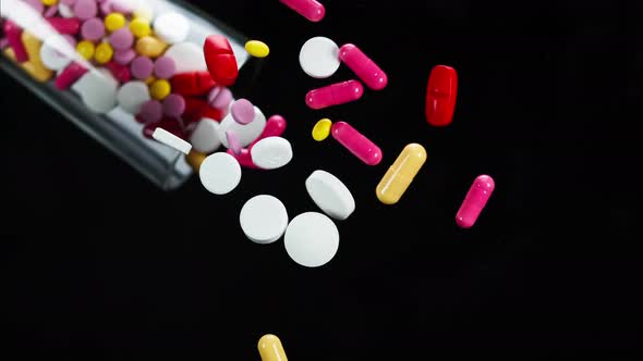 Closeup of Falling Coloured Medicine Tablets From Glass on Black Background Shooting of Fallen Red