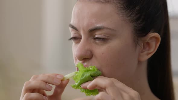 Closeup Face of Happy Young Vegan Woman Eating Green Salad Leaf Enjoying Taste