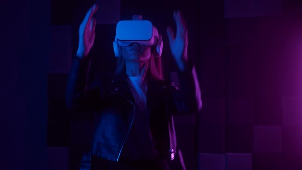 Creative Lady in Futuristic VR Headset Gesturing with Hand While Interacting with Cyberspace Under