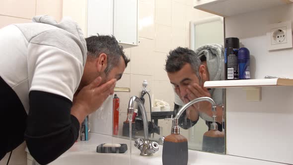 Happy man washing his face.