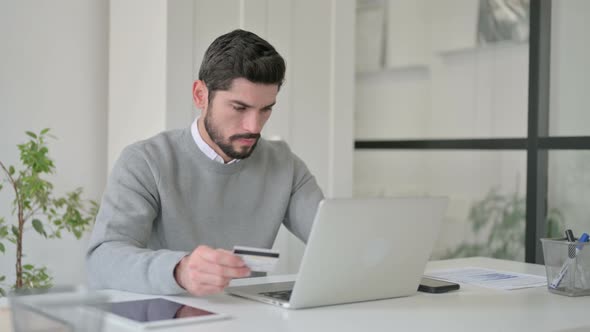 Young Man Making Successful Online Payment on Laptop