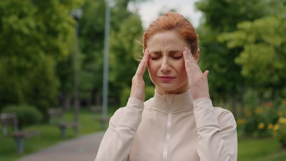 Woman having migraine while jogging