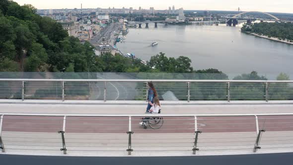 Drone View of Girl and Mom in Wheelchair on Walk