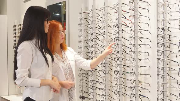 Red-haired Lady Doctor Helps Her Client To Choose Glasses for Vision.