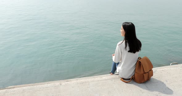 Woman sitting down and enjoy the sea view