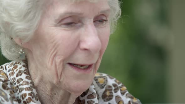 Tight shot of an elderly lady's smiling face.