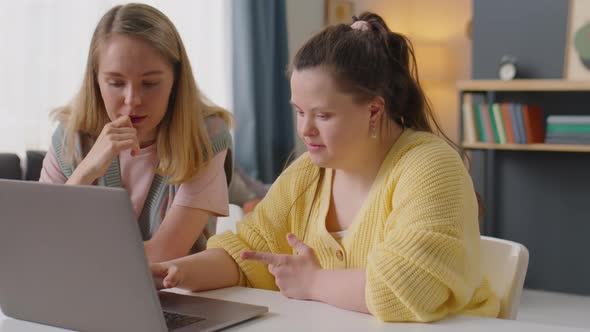 Girl with Down Syndrome Using Laptop with Teacher at Home Lesson