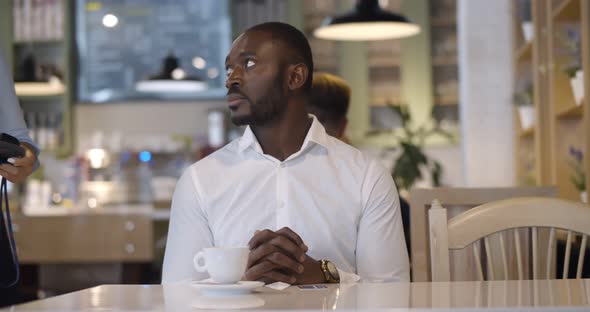 Afroamerican Businessman Making Credit Card Payment in Cafe