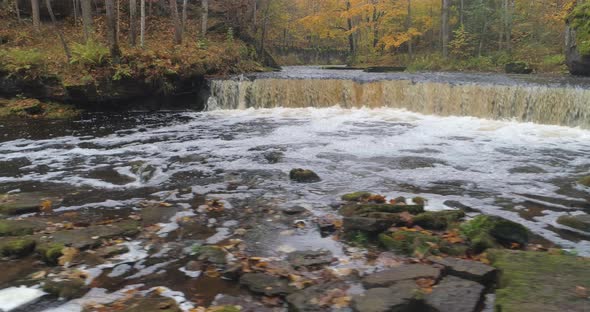 Waterfall And Flowing River In Autumn