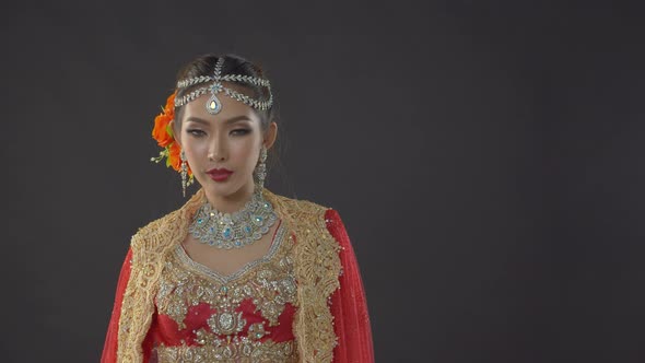 Shy yet alluring Indian bride in traditional dress poses for her wedding portraits