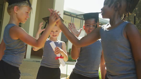 Video of happy diverse boys tossing hats after graduation