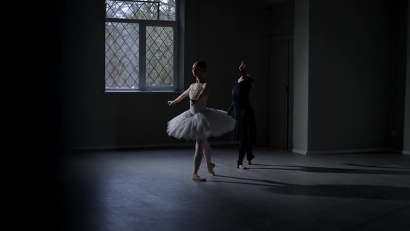 Wide Shot Slim Female Ballet Dancers in White and Black Bending Standing in Fourth Position in