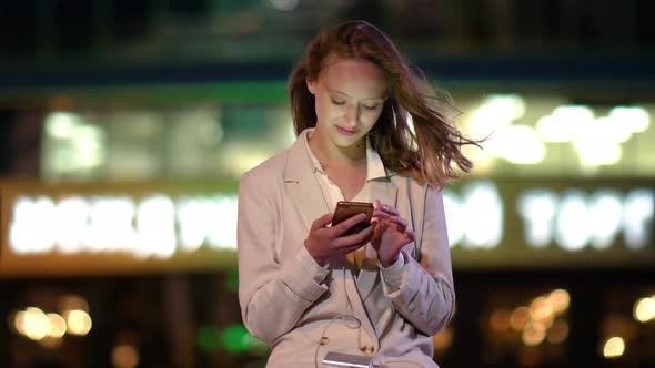 Young Woman Charging Mobile Phone While Using It.