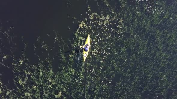 Young male kayaking around in lake Kesankijarvi in Lapland Finland.