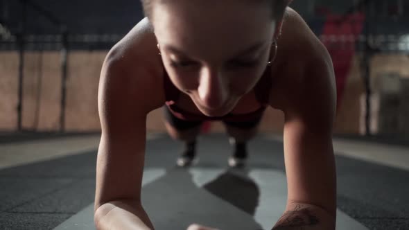 Close Up of Young Woman Doing Plank in Huge Fitness Room