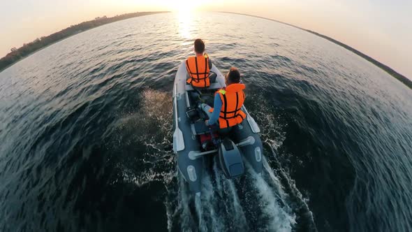 Dinghy with Two Men Onboard Is Crossing the River in a Top View