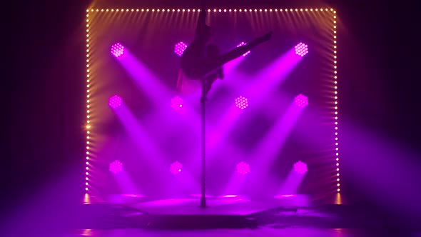 Sporty Pole Dance Performed By a Slender Young Woman in a Dark Smoky Studio