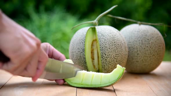 The man use knife split the green melon