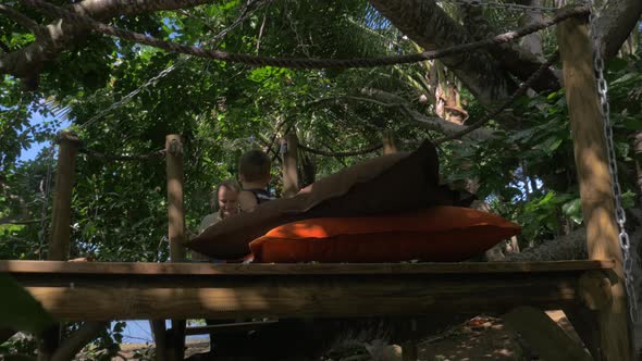 Mother and son relaxing on wooden deck among the trees