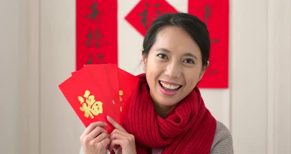 Chinese Woman Holding Red Packet and Feeling Happy, Word on Red Packet Means Luck