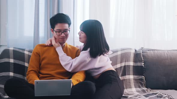 Young Woman Distracting Her Boyfriend From Working