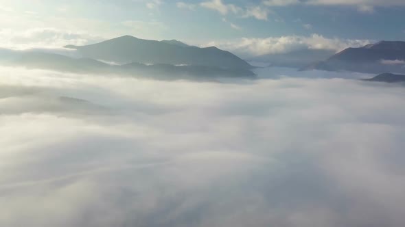 Morning Flight Above Foggy Clouds in Sunny Landscape Reveal Moutnains in Autumn Nature