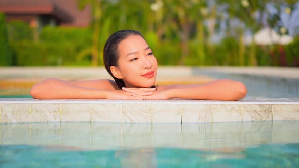 Young asian woman enjoy around outdoor swimming pool for leisure