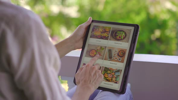 A Man Orders Food for Lunch Online Using Tablet. Online Shoping Concept