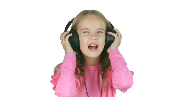 Baby Listens To the Music in the Headphones. White Background