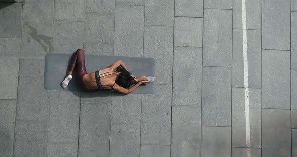 AfricanAmerican Woman Does Stretching Exercises on Mat