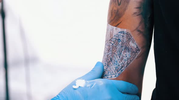 Male Tattoo Artist Tattooing a Client