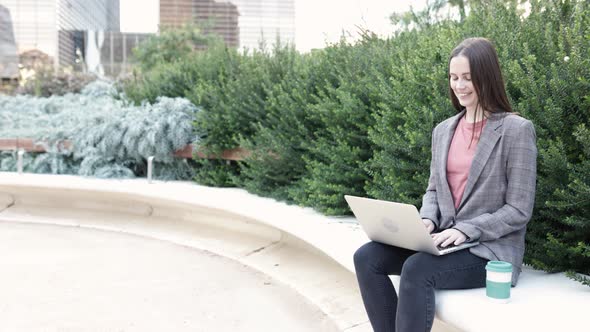 Happy Young Woman Using Laptop Outdoors  Copy Space for Text