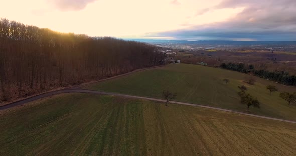 Drone flight above winter forest on a hill.