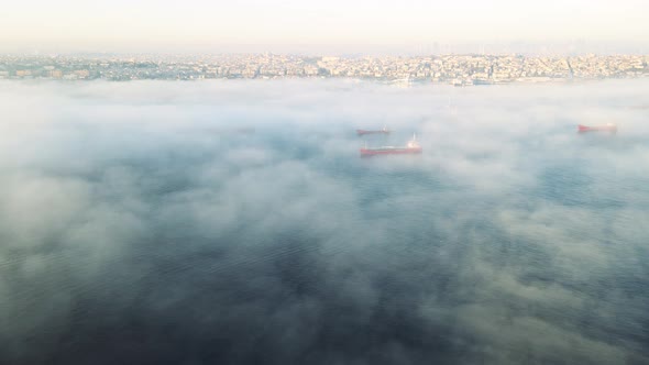 drone flying above sea with city view in foggy day