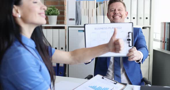 Businessman Showing Business Plan for 2022 Businesswoman Smiling and Holding Thumb Up Slow Motion