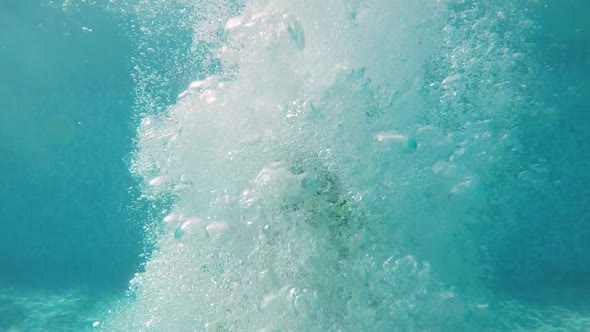 Energetic Boy Jumping Feet First in Pool and Causing Big Splashes in Slo-mo 