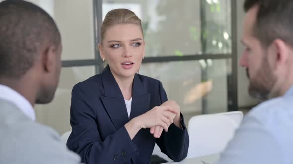 Beautiful Businesswoman Talking to Mixed Race Businessmen in Office